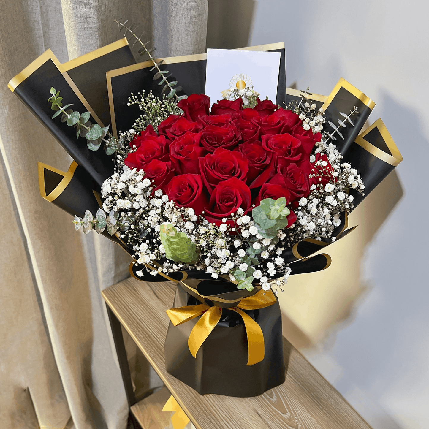 Ramo de 24 Rosas Rojas – Elegancia en Negro y Dorado